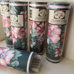 May include: Rolls of floral wallpaper border with a dark green background and large pink and blue flowers. The rolls are labeled "Coordinated Borders by Imperial Wallcoverings". The wallpaper is pre-pasted and strippable.