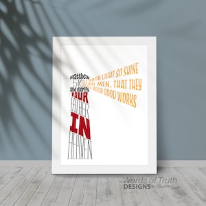 May include: A white framed print with a black and red typography design that reads "Matthew 5:16 Let your light so shine before men, that they may see your good works and glorify your Father in Heaven." The print also includes the text "Words of Truth Designs by Christine Conner".