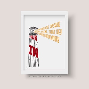May include: A white framed print with a red and gold typography design. The text reads "Let your light so shine before men, that they may see your good works and glorify your Father in Heaven."  Matthew 5:16. The print is signed "Words of Truth Designs".