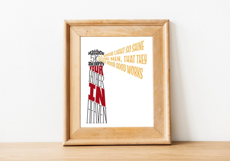 May include: A framed print with a white background and a red and gold text design. The text reads "Matthew 5:16 Let your light so shine before men, that they may see your good works and glorify your Father in Heaven."