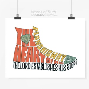 May include: A typography art print with a heart shape and the text "The heart of man plans his way, but the Lord establishes his steps." The text is in a variety of colors, including red, orange, yellow, and green.