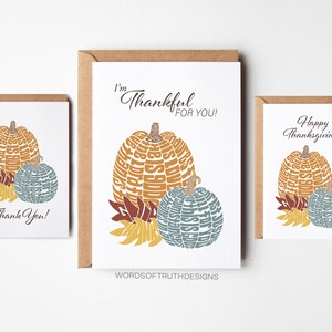 May include: Three Thanksgiving greeting cards with a pumpkin design. The cards feature the words "I'm Thankful for You!" "Happy Thanksgiving!" and "Thank You!" The pumpkins are made of words related to Thanksgiving.