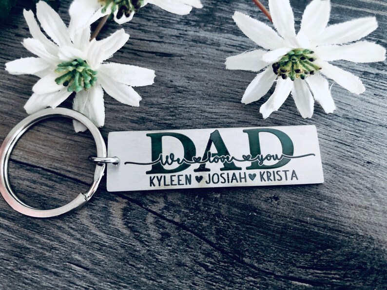 May include: Silver keychain with a rectangular tag that reads "DAD We love you KYLEEN JOSIAH KRISTA". The tag has a black cursive font and three small hearts.