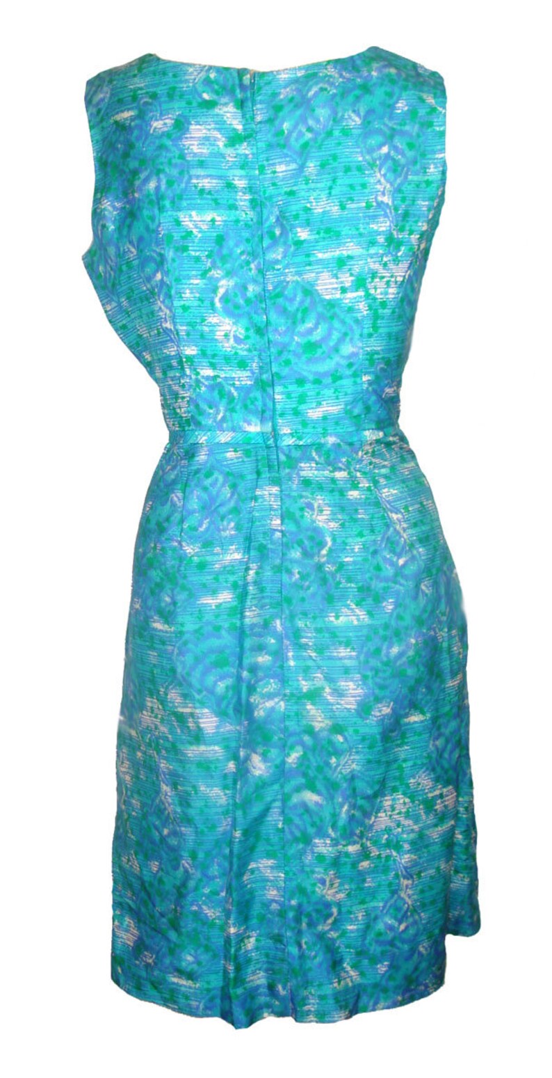 May include: A sleeveless dress with a blue and green floral pattern. The dress has a fitted bodice and a slightly flared skirt.