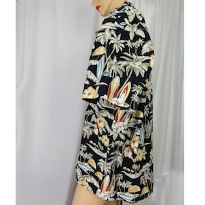 May include: A black short-sleeved button-down shirt with a tropical print featuring palm trees, surfboards, and flowers.