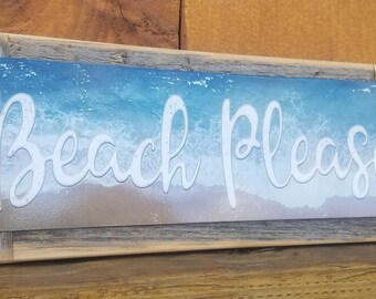 May include: A rustic wooden sign with a metal insert featuring a beach scene and the text "Beach Please" in white cursive lettering.