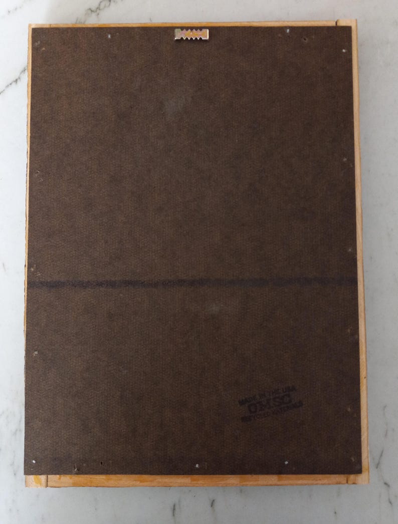 May include: The back of a wooden picture frame with a brown backing and a label that reads "Made in the UK, D.M.S.O. Registered Design".
