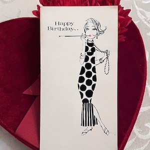 May include: A vintage birthday card featuring a black and white illustration of a woman in a polka dot dress holding a cigarette. The card has the text "Happy Birthday." printed on it.