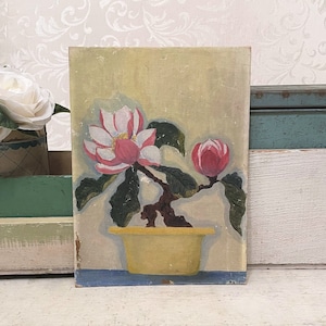 May include: Vintage floral painting featuring a pink and white flower with green leaves and a bud in a yellow pot. The artwork is set against a light yellow background with a blue base, showcasing a classic botanical theme.