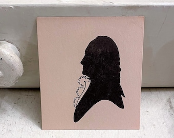 May include: A black silhouette of a person with a large, ruffled collar on a pink background.