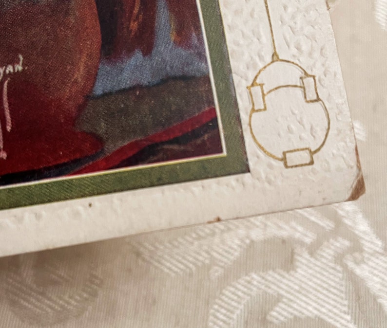 K&ouml;nnte beinhalten: Eine Vintage-Postkarte mit gr&uuml;nem Rand und einem goldenen Design auf der rechten Seite. Die Postkarte zeigt ein Gem&auml;lde einer Frau in einem roten Kleid.