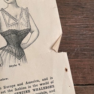 May include: A black and white illustration of a woman wearing a corset. The text "Style V." is below the image. The text "Only GENUINE WHALEBONE different models, and DATISTE" is below the text "Style V."