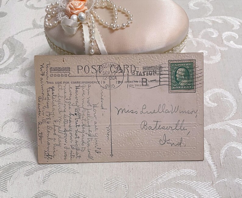 K&ouml;nnte beinhalten: Eine Vintage-Postkarte mit einer handschriftlichen Nachricht an Miss Luella Winsor in Batesville, Indiana. Die Postkarte hat eine gr&uuml;ne Briefmarke mit einem Portr&auml;t von George Washington. Die Nachricht lautet: "Wie geht es dir? Ich f&uuml;hle mich nicht besonders gut. Gib Harvey meine besten Gr&uuml;&szlig;e, aber nicht so laut, dass es jemand h&ouml;rt. Schreib mir bald einen langen Brief. Ich hatte gestern eine sch&ouml;ne Zeit. Ich hatte eine sch&ouml;ne Zeit. Adresse 1786 Wenham St. Airmont, Iowa. Wie immer."