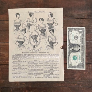 May include: A vintage advertisement for The Classique corsets, featuring illustrations of women wearing different styles of corsets. The ad highlights the corset's popularity in Europe and America, emphasizing its perfect fit and high-quality materials, including silk, satin, and wool.