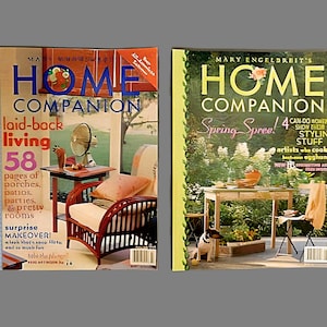 May include: Two copies of Mary Engelbreit's Home Companion magazine. The left magazine features a laid-back living theme with a wicker chair and a side table. The right magazine features a spring-themed cover with a table and chairs on a patio.