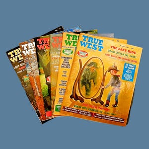 May include: A collection of vintage "True West" magazines fanned out against a blue background. The covers feature illustrations and text, with titles like "The Last Ride" and "Lost Gold". The magazines have a retro aesthetic.
