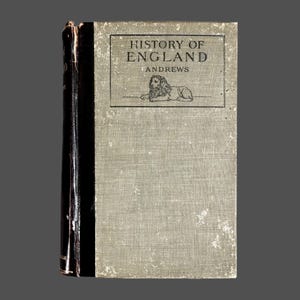 May include: A vintage book titled "History of England" by Andrews. The book has a light gray cover with the title in a black rectangular box, and a lion illustration. The spine is black.