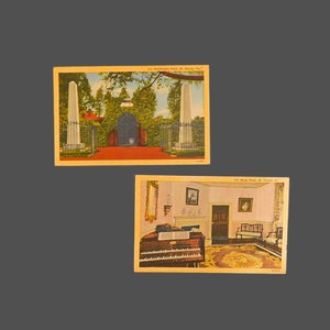 May include: Two vintage postcards depicting historical sites in Mount Vernon, Virginia. The first postcard shows a brick gate with two white obelisks on either side. The second postcard shows a room with a pipe organ, a bench, and a rug.