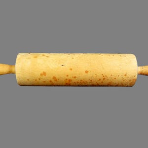 May include: A wooden rolling pin with a cylindrical body and two rounded handles. The rolling pin is light-colored with darker spots and is designed for rolling out dough. A classic kitchen tool.