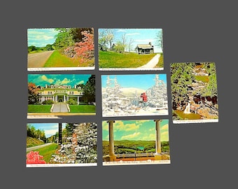 May include: Six vintage postcards featuring scenic views of a mountain resort. The postcards show a road winding through a forest, a white building with a porch, a snowy mountain scene, a waterfall, and a view from a balcony.