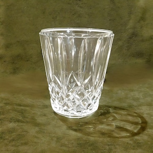 May include: A clear glass vase with a cut-glass design. The vase has a wide mouth and a round base.