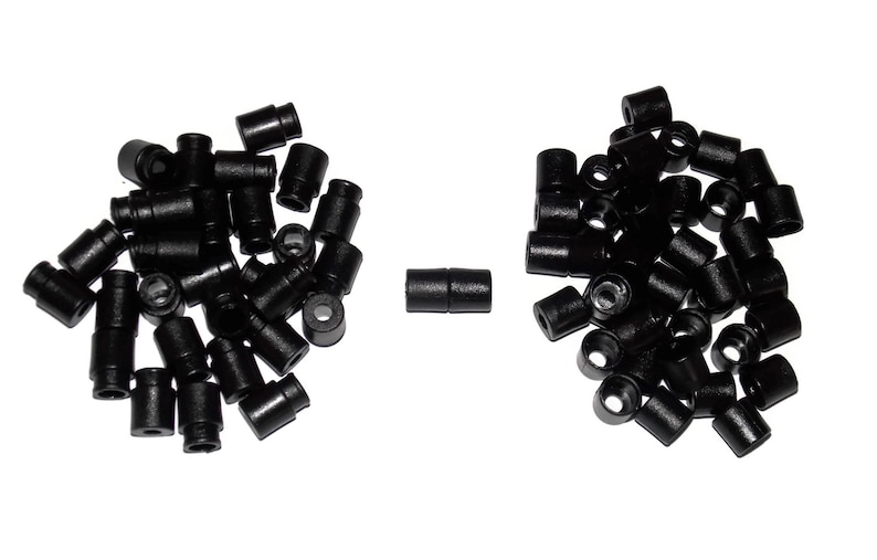May include: A large quantity of black plastic end caps, with two additional end caps joined together in the centre of the image.