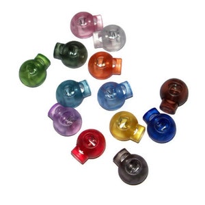 May include: Assortment of 12 colorful plastic toggle stoppers. The stoppers are translucent and come in a variety of colors, including red, blue, green, yellow, and purple.