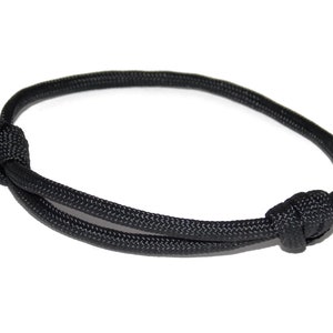 May include: A black paracord bracelet with a simple knot design.