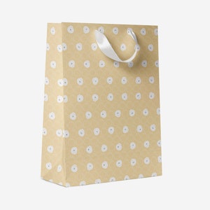 May include: A light brown gift bag with a white ribbon handle and a white polka dot pattern.