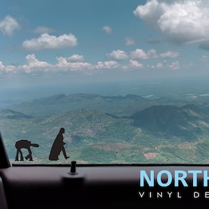 May include: A black and white silhouette of Darth Vader and a droid walking on a leash, with a mountain range and blue sky in the background. The text "NORTH 21 VINYL DECALS" is at the bottom of the image.