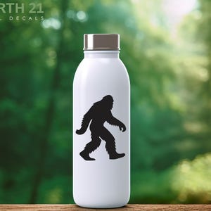 May include: White water bottle with a silver cap featuring a black silhouette of Bigfoot walking. The text "NORTH 21 VINYL DECALS" is printed at the top of the bottle.