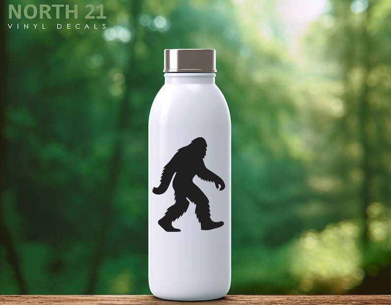 May include: White water bottle with a silver cap featuring a black silhouette of Bigfoot walking. The text "NORTH 21 VINYL DECALS" is printed at the top of the bottle.