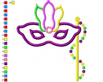 May include: A purple and green Mardi Gras mask with a yellow stick and beads. The mask has a pink circle in the center and a feather design on top. The beads are green and yellow.