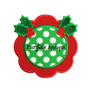 May include: Red and green Christmas applique with a white polka dot circle in the centre. The circle has the text "Fairytale Applique" inside.