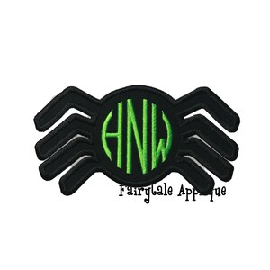 Op de afbeelding: Zwarte spin-applicatie met een groen monogram in het midden. Het monogram luidt "HNW".