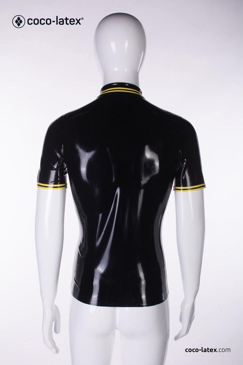 May include: Black short-sleeved shirt with yellow trim around the collar and sleeves. The shirt is made of shiny latex.