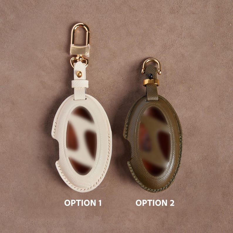 Two oval-shaped keychains with different colors and designs are displayed side by side.