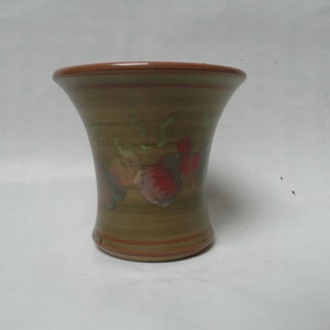 May include: A brown ceramic vase with a flared opening and a green and brown striped design. The vase is decorated with painted red, green, and brown flowers.