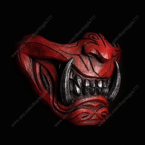 May include: A red and silver Oni mask with a fierce expression. The mask has sharp teeth and horns, and is decorated with intricate details.