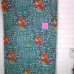 May include: A teal fabric with a repeating pattern of a figure in red and yellow, surrounded by white stars. The figure is labeled "Peter Max". A pink sticker with the number "1716" is visible.