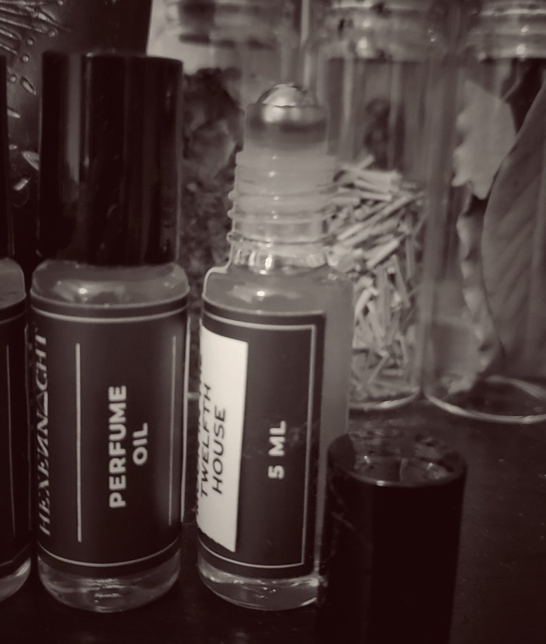 5 ml bottle with clear glass bottle, stainless steel rollerball, black cap, and black & white Hexennacht label/logo.