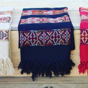 May include: Three woven shawls with fringe, one white, one black, and one red, each with a geometric pattern.