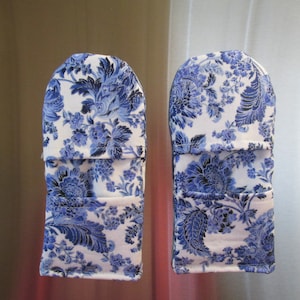 May include: A pair of blue and white floral oven mitts. The mitts have a quilted design and are perfect for protecting your hands while cooking.