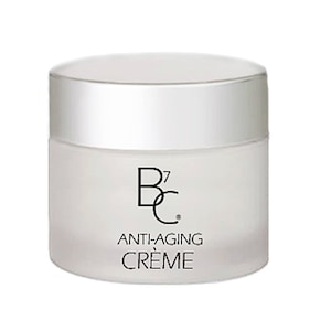 Puede incluir: Un tarro blanco con tapa plateada que contiene una crema antiedad blanca. El tarro tiene el texto "B7C" y "ANTI-AGING CREME" impreso.