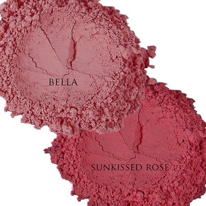 Pode incluir: Dois tons de p&oacute; de blush, um rotulado como "BELLA" e o outro como "SUNKISSED ROSE".