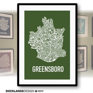 May include: A green and white typography art print of the city of Greensboro, North Carolina. The print features the names of neighborhoods and landmarks within the city's outline.