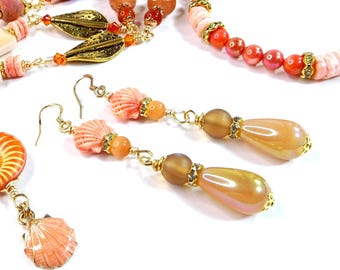 Pendientes colgantes de concha de vieira: joyas inspiradas en el océano, en coral y oro.