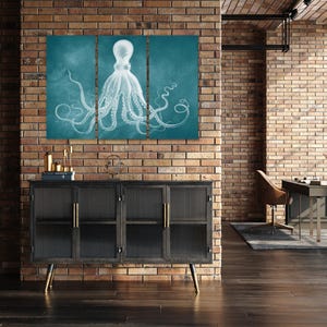 a modern interior design with a large, three-piece wall art depicting an octopus. The wall art is mounted on a brick wall, and the room includes a black cabinet, a desk, and a chair.