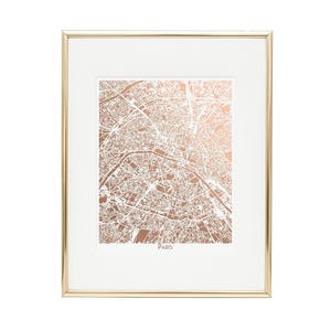 A rose gold foil map of Paris shown in a gold frame.