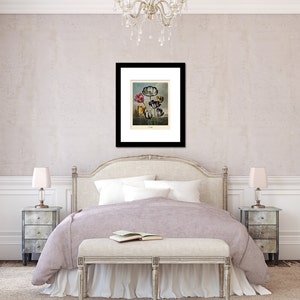 May include: A framed botanical print featuring colorful flowers, displayed above a bed in a bedroom setting. The print has a black frame and is mounted on a white mat. The bedroom has a neutral color palette with a bed, nightstands, and a bench.